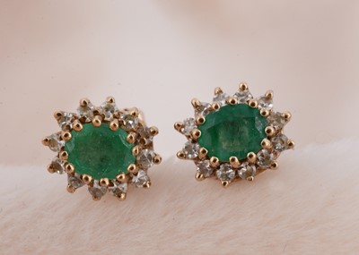 Lot 99 - A pair of emerald and diamond cluster earrings