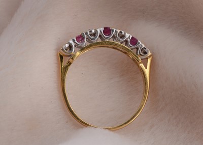 Lot 100 - A ruby and diamond 18ct gold seven stone dress ring