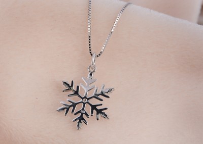 Lot 114 - A 9ct gold diamond set snowflake designed pendant