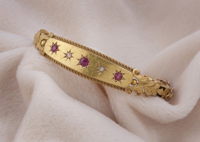 Lot 127 - An Edwardian 15ct gold ruby and diamond bangle