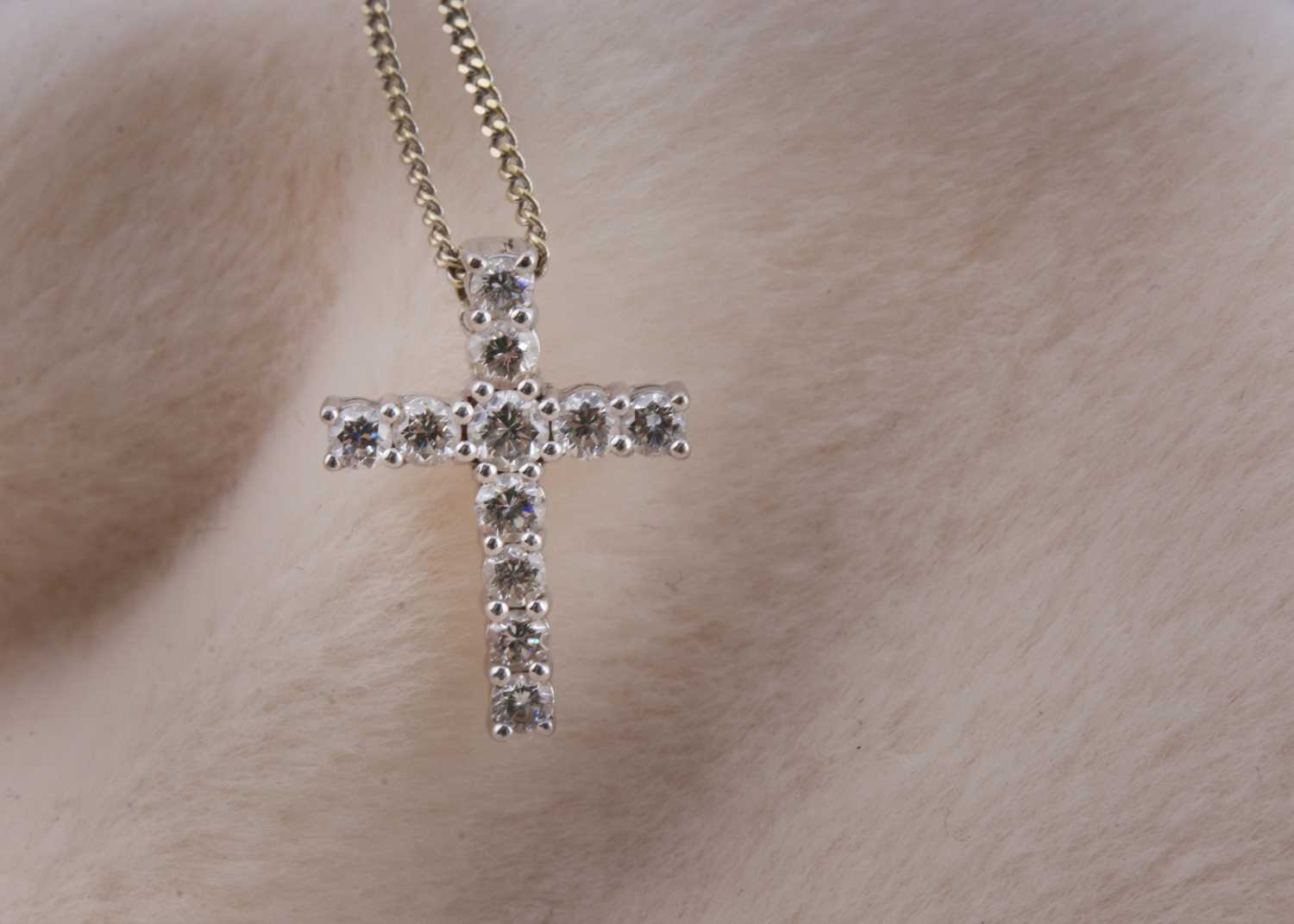 Lot 137 - An 18ct white gold diamond set cross pendant on a white gold fine curb link chain