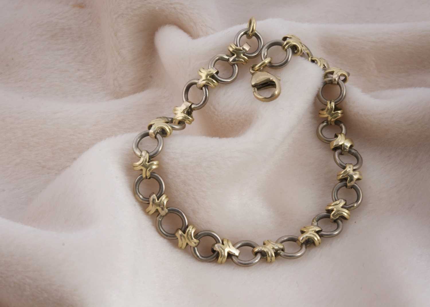 Lot 154 - An 18ct gold two colour circle and cross designed bracelet