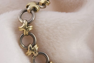 Lot 154 - An 18ct gold two colour circle and cross designed bracelet
