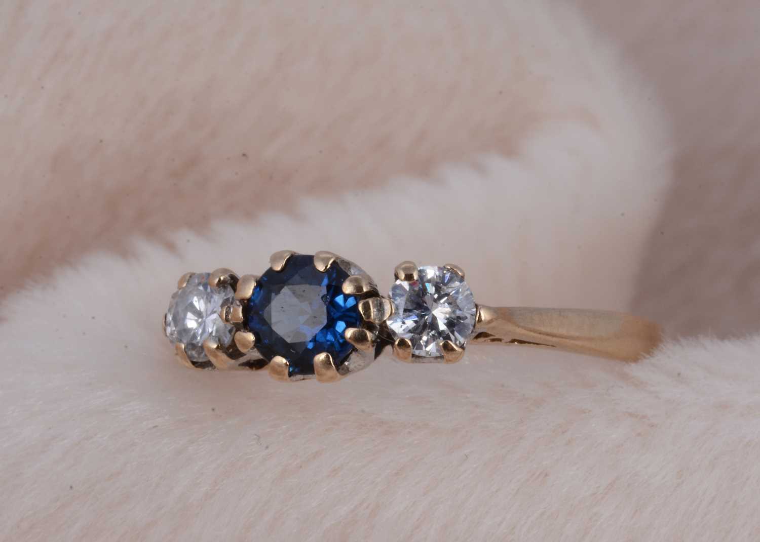 Lot 164 - A three stone 9ct gold sapphire and diamond ring