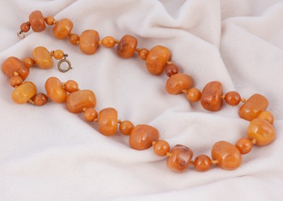 Lot 213 - A string of boulder butterscotch amber beads