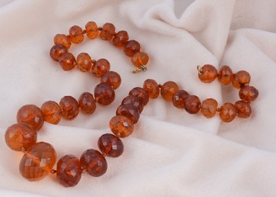Lot 214 - A string of faceted graduated translucent amber beads