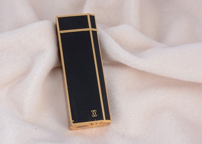 Lot 223 - A gold plated and black enamel rectangular Cartier pocket lighter