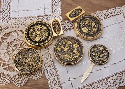 Lot 318 - A collection of gilt metal and black enamel decorated compacts