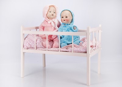 Lot 283 - A pink wooden doll’s cot with dolls
