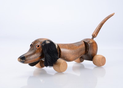 Lot 679 - A wooden pull along articulated sausage dog by Bally (shoes?) Toys