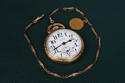Lot 102 - An early 20th century Elgin open faced pocket watch with a gold plated chain and a gold half sovereign