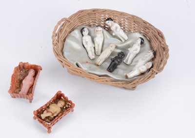 Lot 525 - Two interesting miniature wax babies in cribs and Frozen Charlotte pudding charms