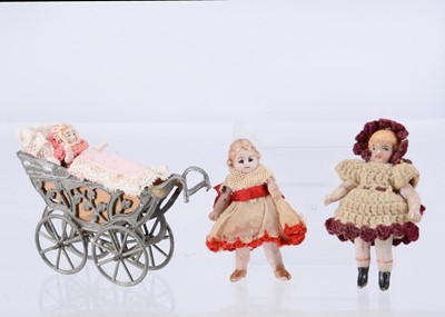 Lot 642 - A German all-bisque tiny doll in a metal perambulator and two others