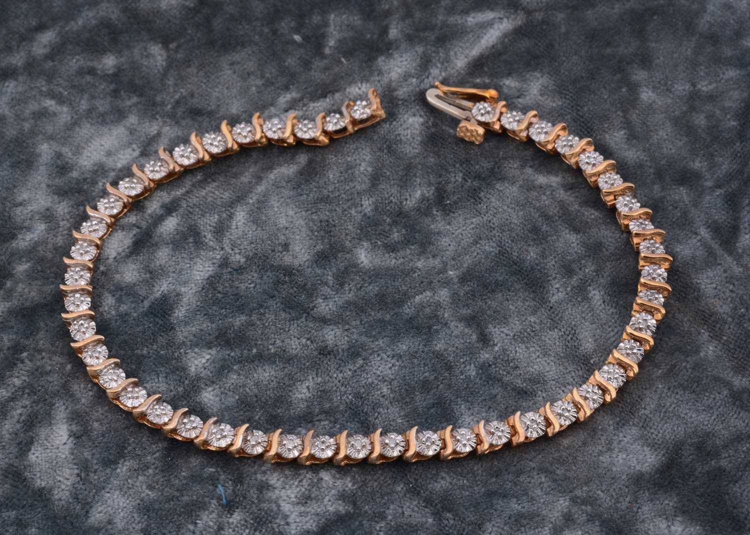 Lot 60 - A 9ct gold diamond set line bracelet