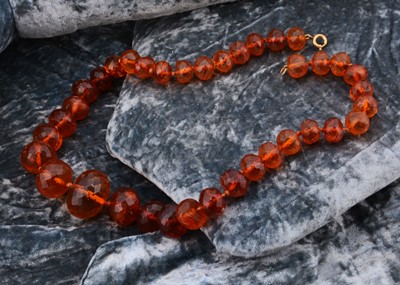Lot 162 - A string of faceted graduated translucent amber beads