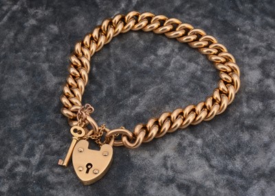 Lot 203 - An 18ct marked curb linked bracelet with padlock clasp with working key
