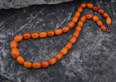 Lot 209 - An amber string of graduated beads