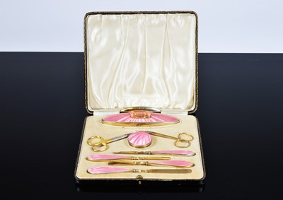 Lot 334 - A George V silver and pink enamelled cased manicure set