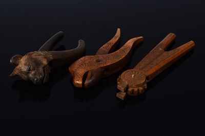 Lot 453 - A late 19th century or early 20th century Black forest carved wooden nut cracker in the form of a bears head