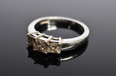 Lot 207 - A platinum three stone princess cut diamond dress ring
