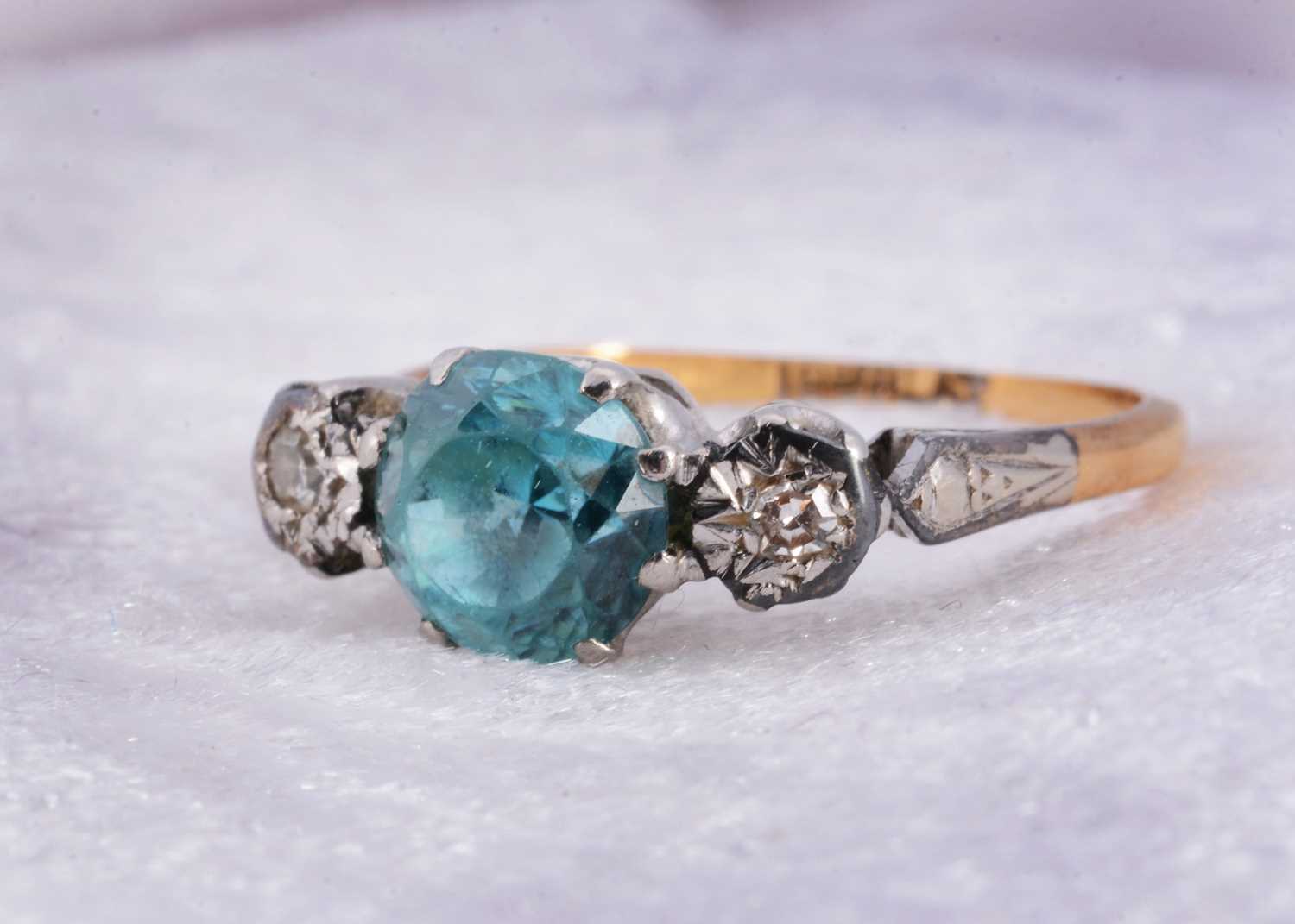 Lot 10 - An 18ct gold and platinum zircon and diamond three stone dress ring