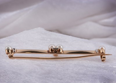 Lot 13 - An Edwardian gold and platinum pearl and diamond bar brooch