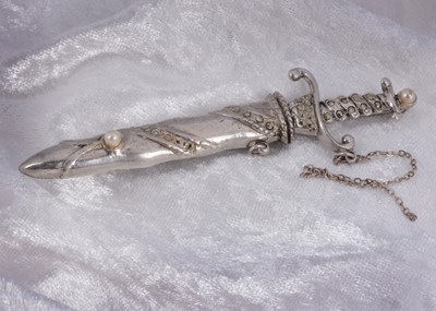 Lot 32 - A silver marcasite and simulated pearl sword brooch