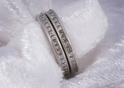 Lot 48 - A pair of platinum Pravins diamond set eternity bands