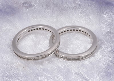 Lot 48 - A pair of platinum Pravins diamond set eternity bands