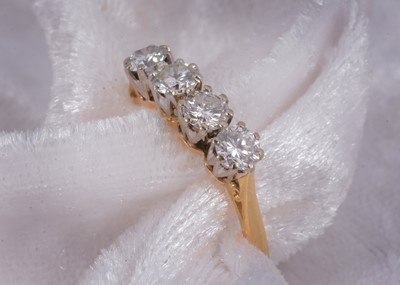 Lot 52 - An 18ct gold four stone diamond dress ring