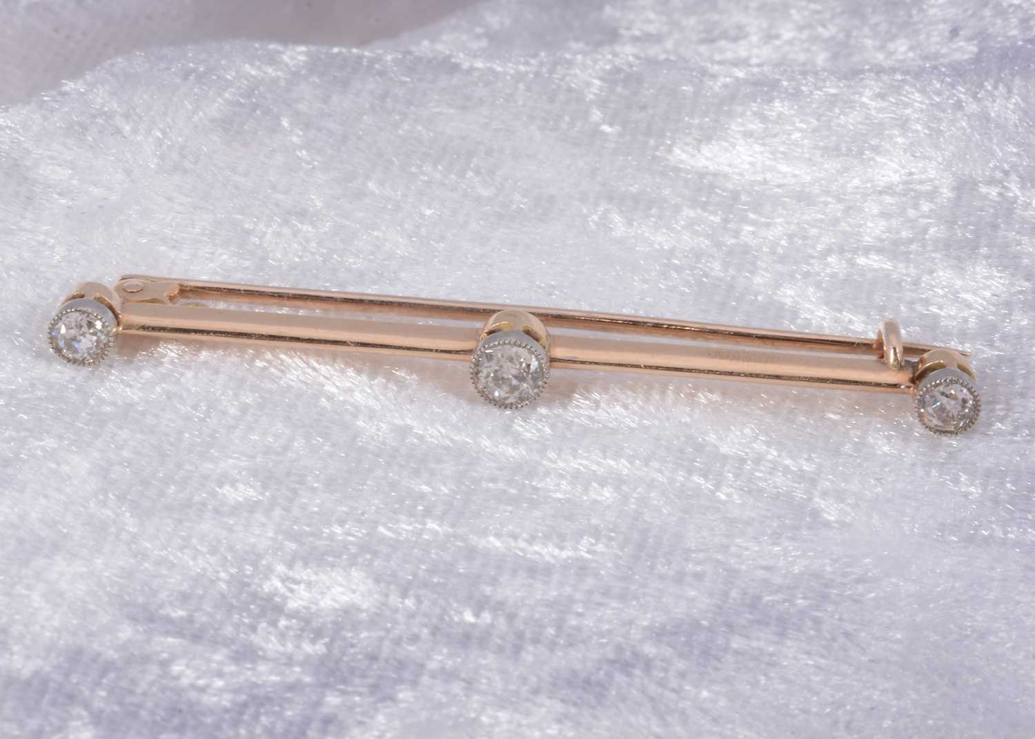 Lot 78 - A three stone diamond bar brooch