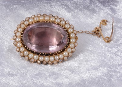 Lot 84 - An oval amethyst and seed pearl foil backed brooch