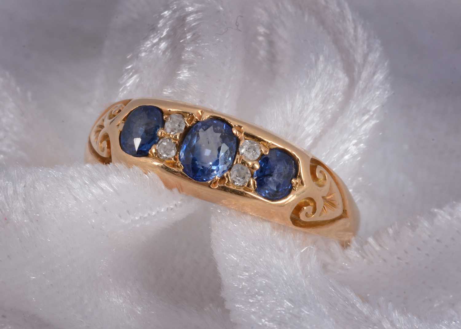 Lot 93 - An 18ct gold three stone sapphire and diamond dress ring