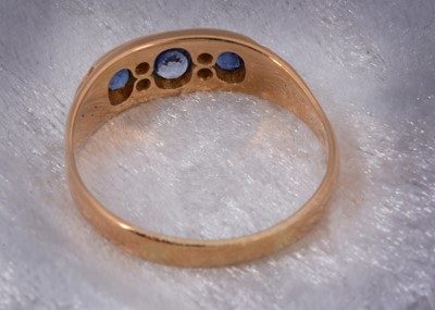 Lot 93 - An 18ct gold three stone sapphire and diamond dress ring