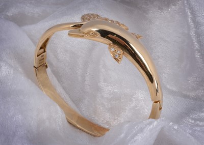 Lot 103 - A continental 14k 585 marked dolphin bangle