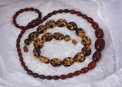 Lot 130 - A string of graduated 'cherry amber' oval bead necklace