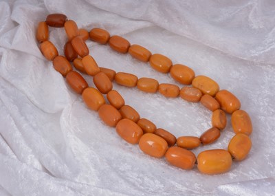 Lot 132 - A large string of ovoid butterscotch amber beads