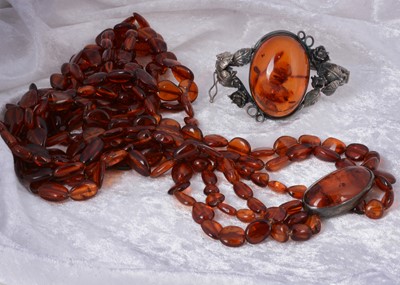 Lot 134 - A Baltic amber and white metal bangle