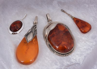 Lot 138 - Four amber pebble shaped pendants