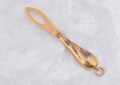 Lot 252 - A continental yellow metal diamond set button loop