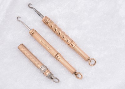 Lot 256 - Three gold plated cylindrical sliding button hooks