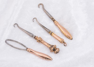 Lot 257 - Four Victorian 9ct gold button hooks and loops