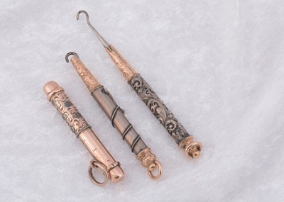 Lot 265 - Three bi metal pull out button hooks