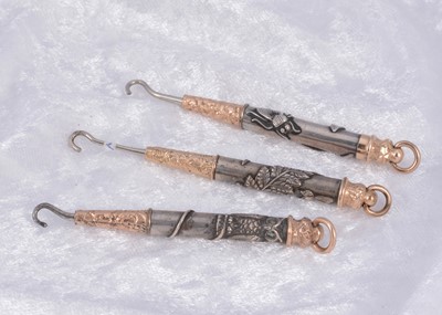 Lot 281 - Three bi metal propelling button hooks