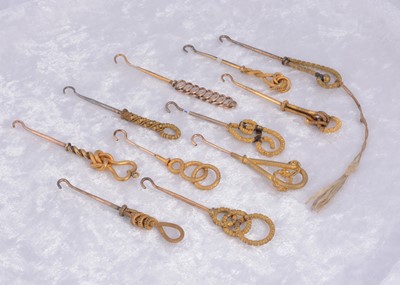 Lot 284 - A collection of eleven textured knot design gilt metal button hooks