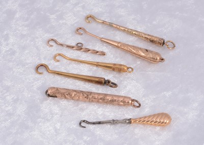 Lot 285 - Seven unmarked yellow and gilt metal button hooks