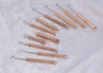 Lot 287 - Ten gilt metal protracting and pull out sleeve button hooks