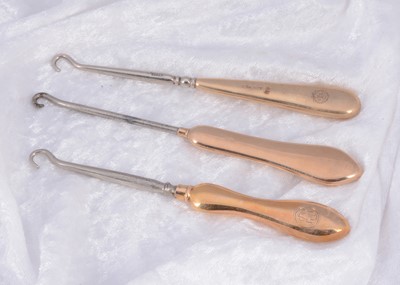 Lot 295 - Three plain handled 9ct gold button hooks