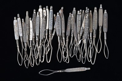 Lot 445 - A collection of steel advertising glove button loops