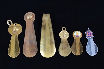 Lot 466 - Five brass and one steel commemorative or souvenir shoehorns